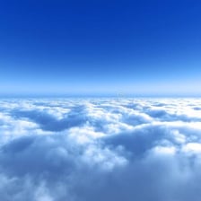 A clear blue sky viewed above a layer of clouds.