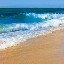 Ocean waves breaking along a sandy shore
