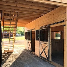 A wooden barn with hay stored in its loft