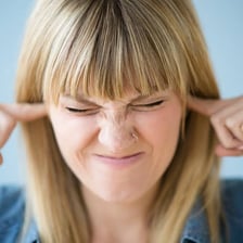 A visibly irritated person reacting to an annoyance.