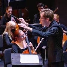 A conductor indicating musical tempo to an orchestra