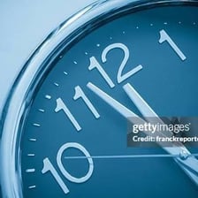 A close view of an analog clock face and hands.