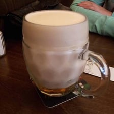 A glass of ale with a foamy head