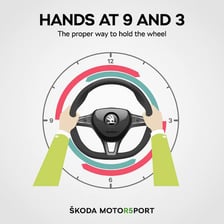 A driver’s hands holding a car steering wheel.