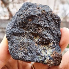 A dark magnetite rock specimen identified as iron ore