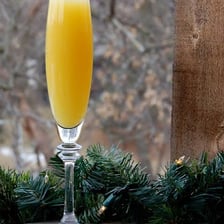A glass of mimosa made with sparkling wine and orange juice