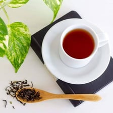 Loose black tea leaves and a cup of brewed tea