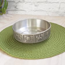 A pewter bowl shown beside a piece of tin metal.