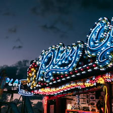 Colorfully lit carnival rides, including a Ferris wheel.