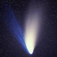 A bright comet with a tail moving through a star-filled space scene.