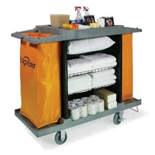A hotel housekeeper working beside a room-service cart