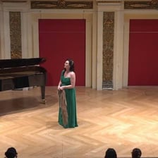 An opera singer performing a solo aria on a theatrical stage