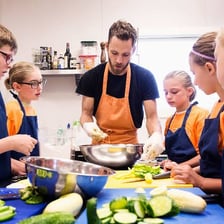 Students learning cooking skills in a home economics classroom.