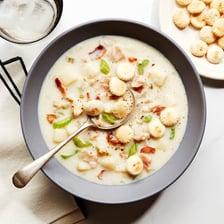 A bowl of clam chowder containing visible clam pieces.