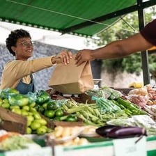 A shopper obtaining groceries in a market.