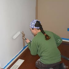 Person applying paint to an interior wall
