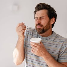 A person showing disgust while reacting to unpleasant food.