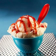 A single scoop of ice cream in a bowl.