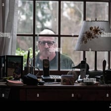 A person peeking through a window in a curious, intrusive way.