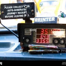 A fare meter mounted on the dashboard of a taxi.