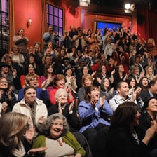 A sitcom audience reacting with laughter during a television recording
