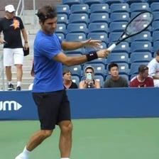 A tennis player focusing intently on an approaching ball.