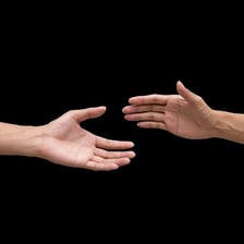 Two people shaking hands after an apology or reconciliation.