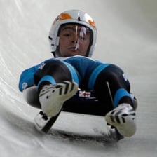 A luge athlete racing feet-first on a sled