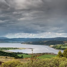 A coastal landscape showing a narrow sea inlet, or firth.