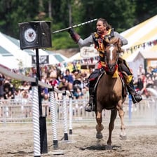 Two armored riders charging one another with lances at a Renaissance Faire
