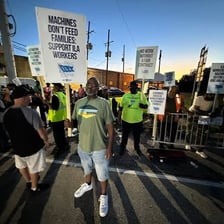 Striking workers standing together on a picket line.