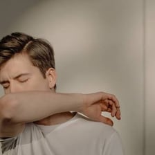 A person clearing their throat before speaking