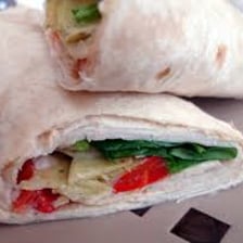 Rolled flatbread wraps filled with vegetables and chicken.