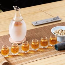 Small glasses of Japanese sake being used for a toast.