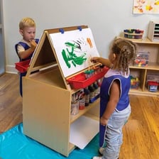 An art classroom containing easels and painting supplies.