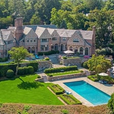 A large house set within expansive estate grounds.