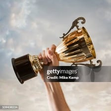 A victorious person holding a trophy