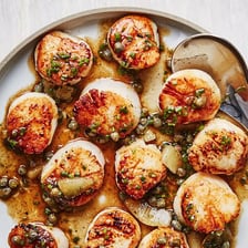 Pan-seared scallops served on a plate.