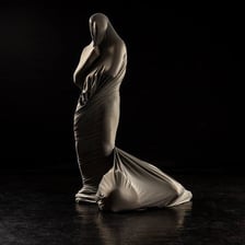 Hands tightly wrapping an object in a strip of cloth