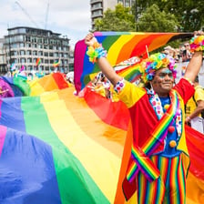 People at a Pride parade carrying rainbow flags.