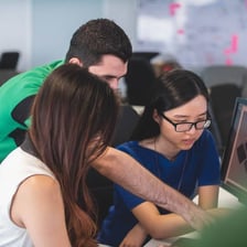 Young office interns working together at desks