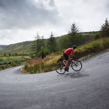 Cyclist riding uphill on a steep road