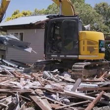 A demolition crew reducing a building to rubble.