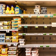 A mostly empty grocery shelf with just a few products left.
