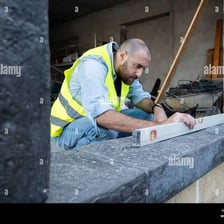 A worker using a level to align a surface