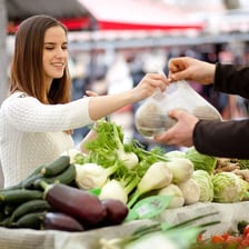 A person standing watch beside fresh produce.
