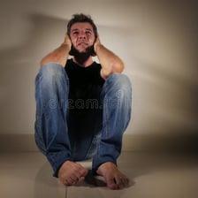 A person crying while sitting alone.