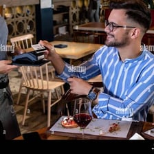 A person paying a restaurant bill with a credit card.