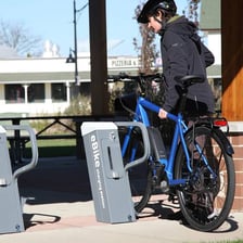 Electric bicycles with visible batteries parked near a charging station