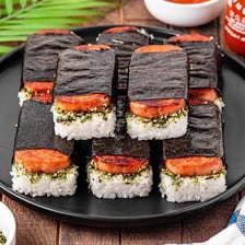 A piece of spam musubi wrapped with a strip of nori.